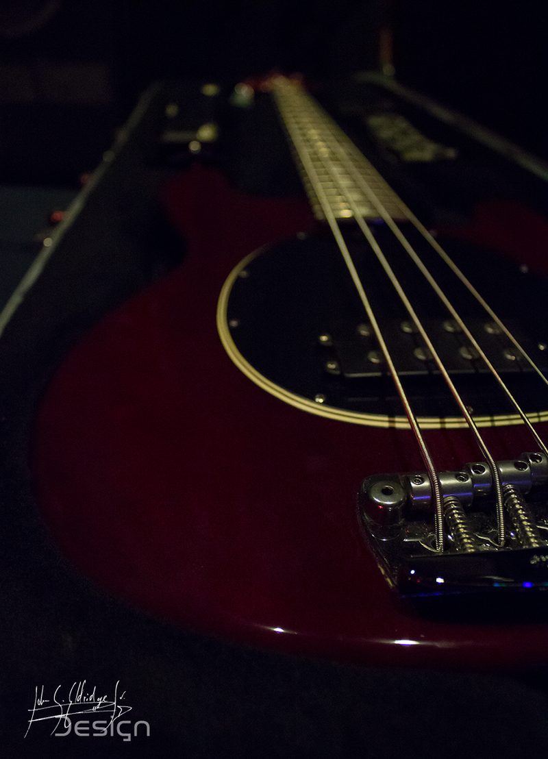Bass laid across a case in the dark, the one deliberately still frame of the night.