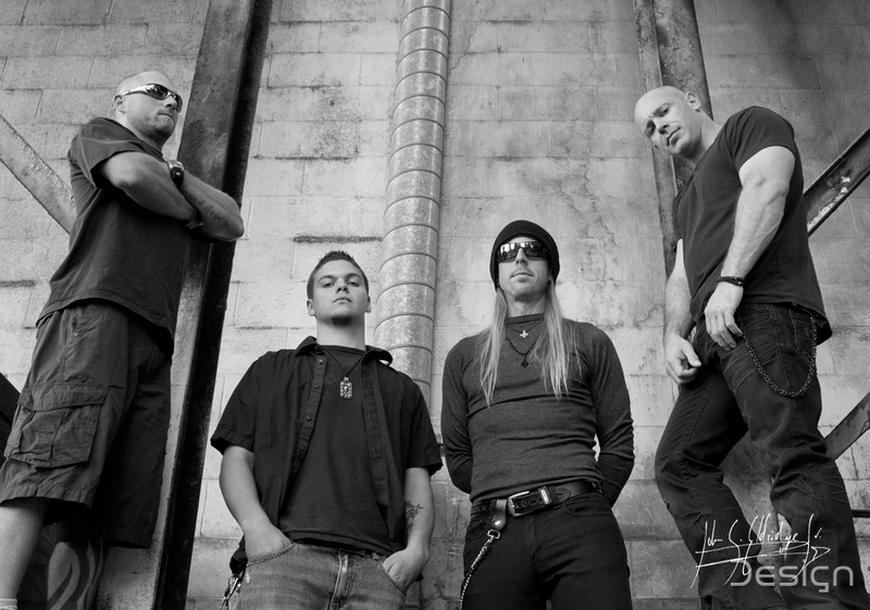 Promo session — the four of them against a bare exterior wall, flat daylight, no styling.