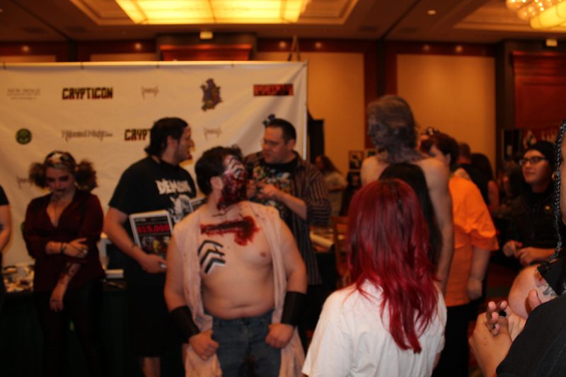 Crypticon 2012 — gore makeup cosplayer at the step-and-repeat banner